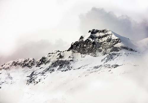 mountain range glacier mountain under white sky outdoors